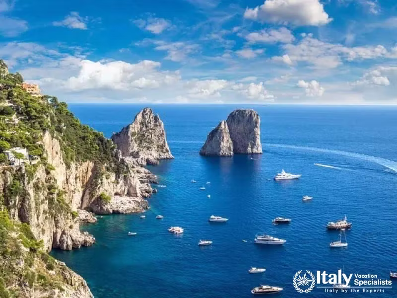 Boats sailing around Capris iconic Faraglioni rocks.
