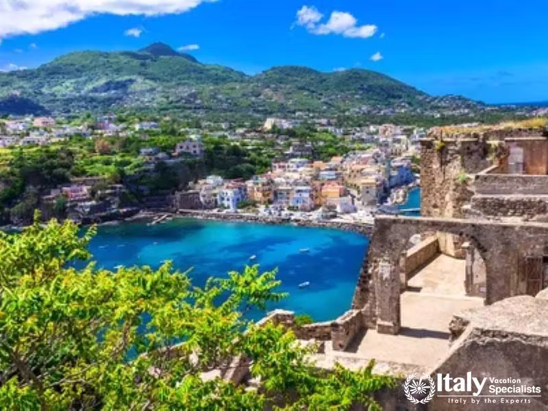 A vivid view from the heights overlooking the lush and vibrant coastal town of Ischia.