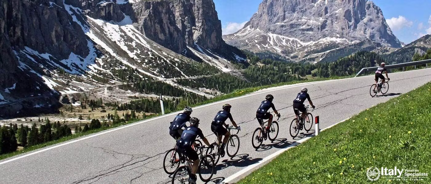Cyclists on a mountain road with Dolomite peaks in the background.