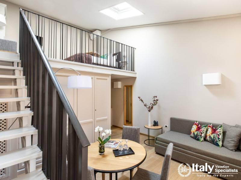 A modern loft suite with an open layout, featuring a mezzanine bedroom.