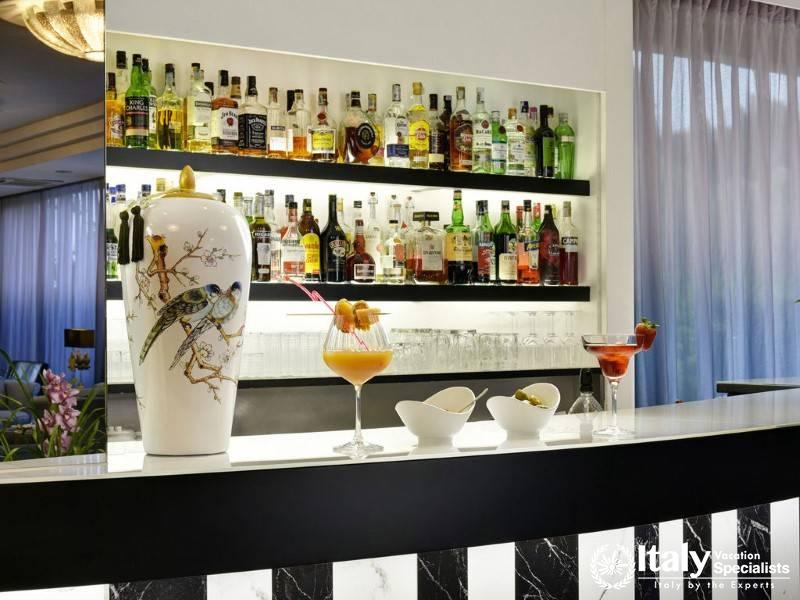 A stylish hotel bar with a variety of beverages on display, featuring cocktails and a chic ambiance.