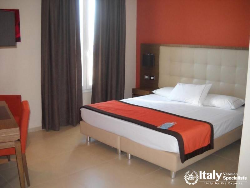 A contemporary bedroom with a large bed and vibrant red accents.