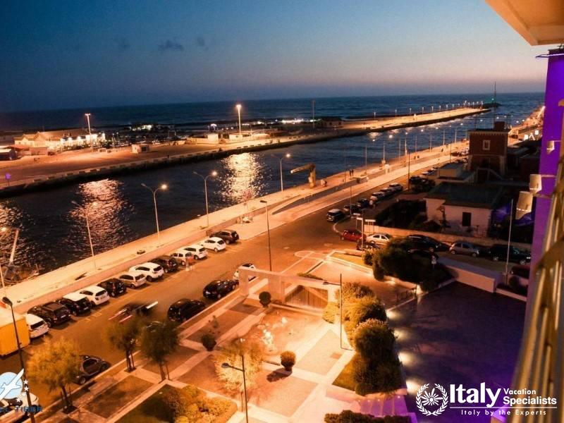 A beautiful nighttime scene of a vibrant harbor and city lights reflected on the water.