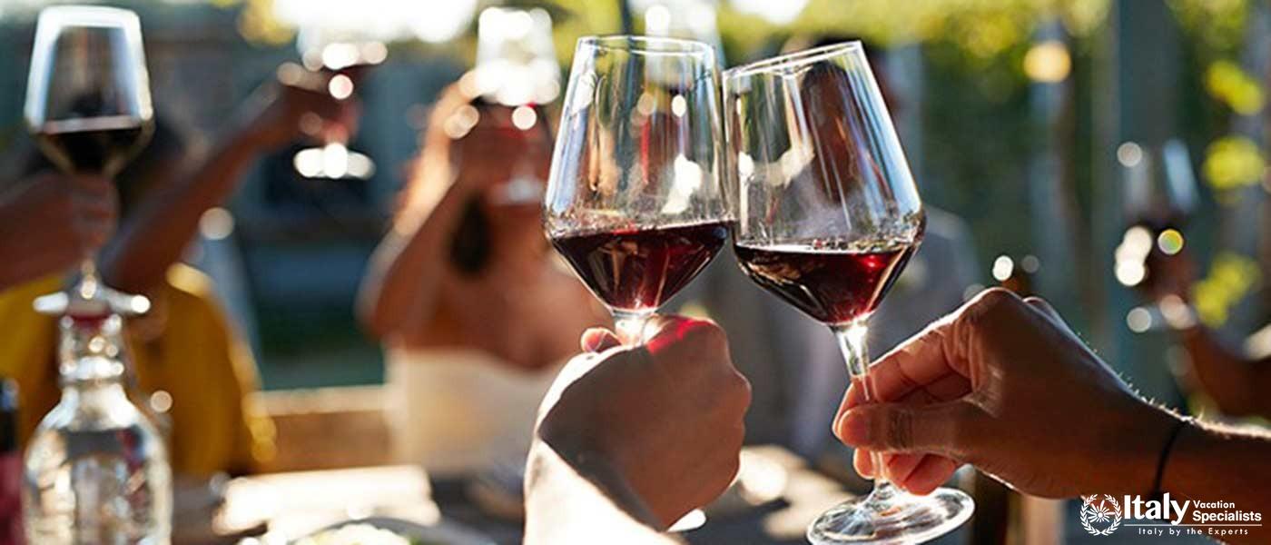 Guests enjoying a toast with Guardastelle's exquisite wines under the Tuscan sun.