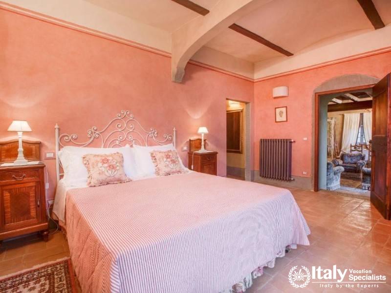 A bright and airy bedroom featuring a soft color palette and classic Tuscan charm.