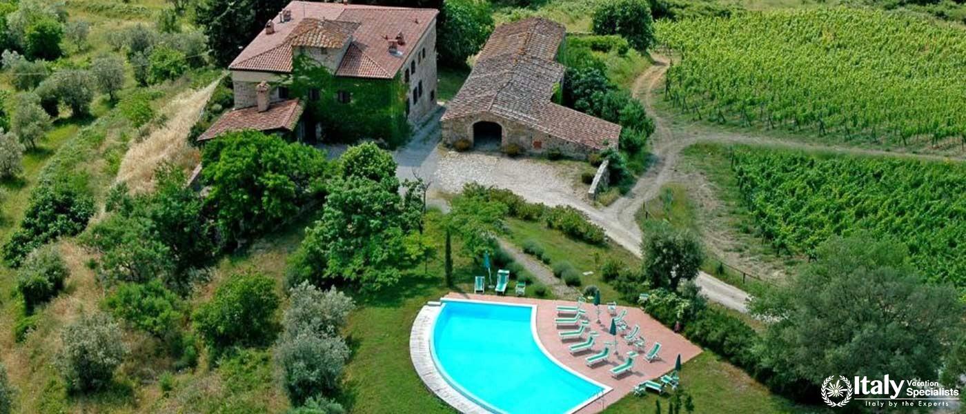 Enjoy a serene view of our vineyard and pool, set amidst the rolling Tuscan hills.