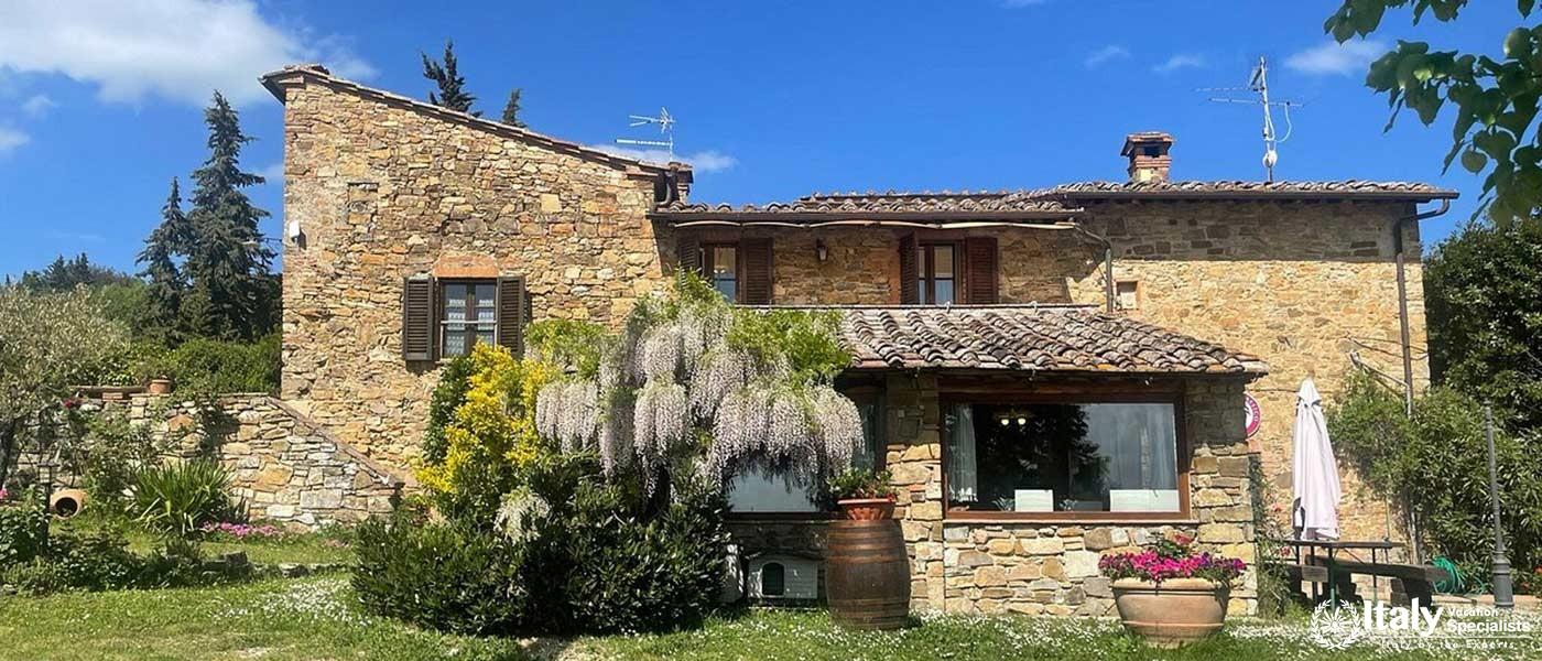 A charming stone farmhouse amidst lush gardens at Sant'Agnese Farm.