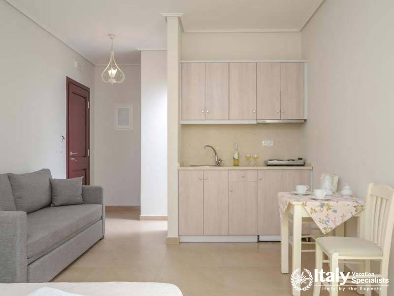Compact kitchen space with a cozy dining setup at Perla Hotel in Naxos, Greece Compact kitchen space with a cozy dining setup at Perla Hotel in Naxos, Greece