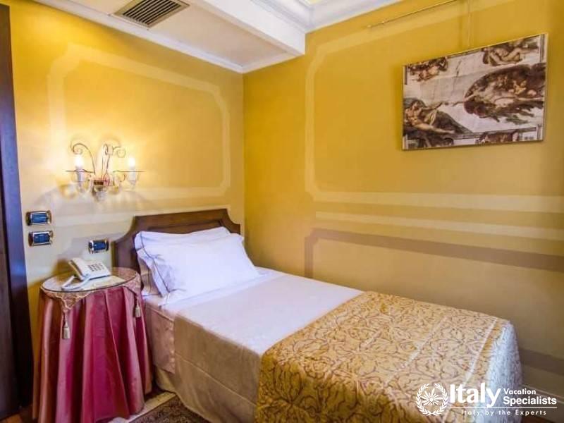 A cozy single room, adorned with classical art, provides a peaceful retreat in Hotel Al Codega.