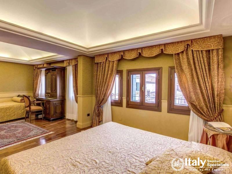 A junior suite with abundant daylight and elegant furnishings promises relaxation at Hotel Al Codega