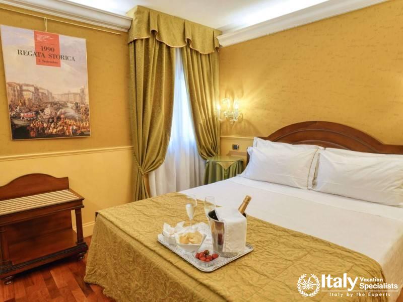 A romantic setup with wine and strawberries in a serene room at Hotel Al Codega.