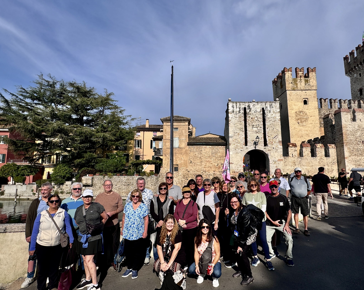 A tour group in front of a medieval castle in northern Italy